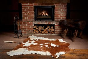 Prémium valódi marhabőr szőnyeg, rusztikus nappali dekorációban.