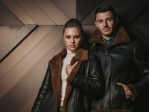 Modern men's and women with shearling jacket made from premium lamb fur.