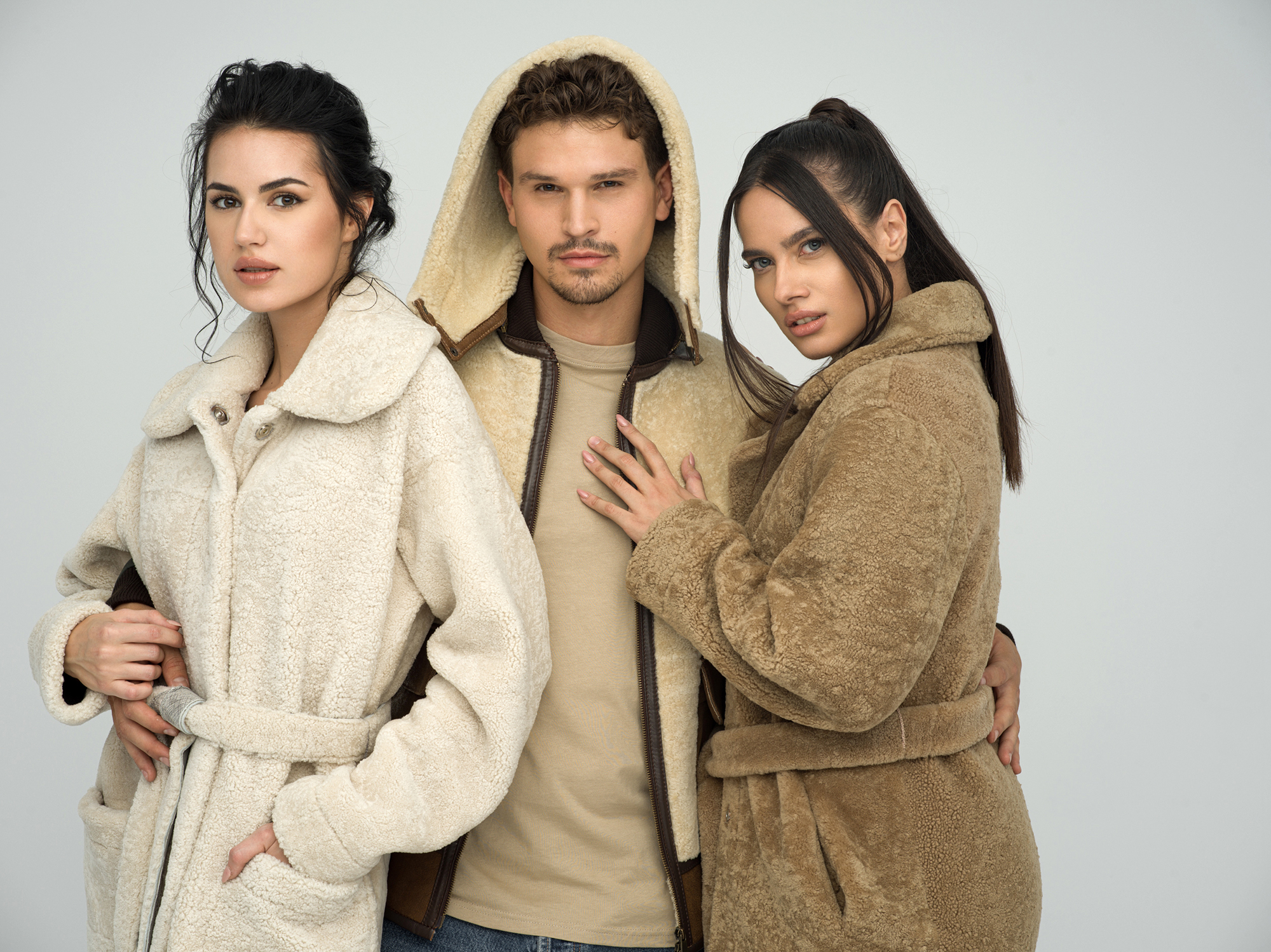 Two women in shearling coat and a man in shearling jacket