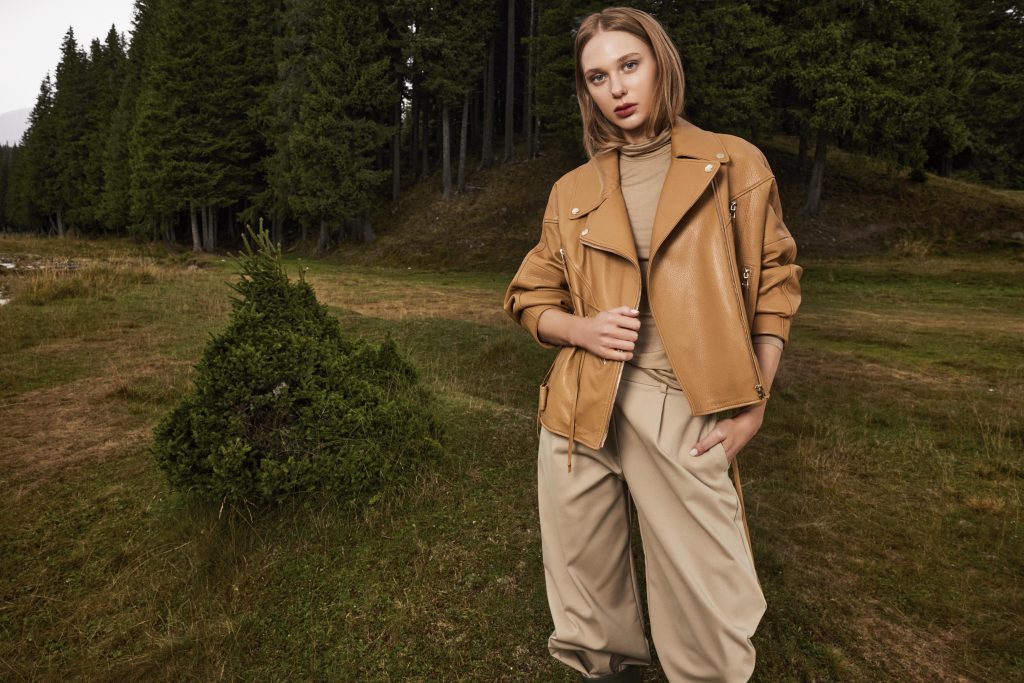 Confident woman wearing a yellow bomber leather jacket for women with zippers